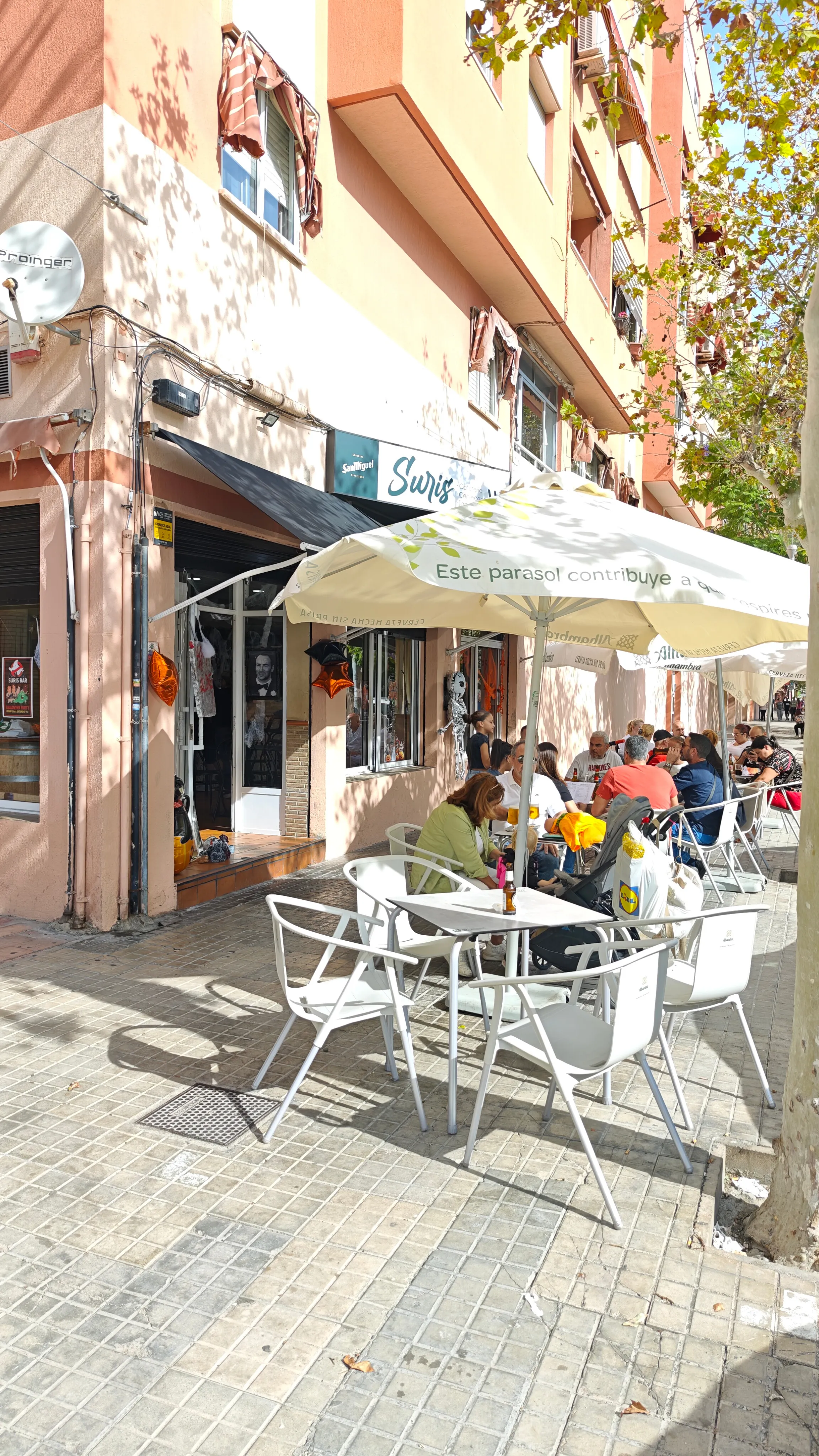 Terraza de Suris Bar con sombrillas y clientes en las mesas